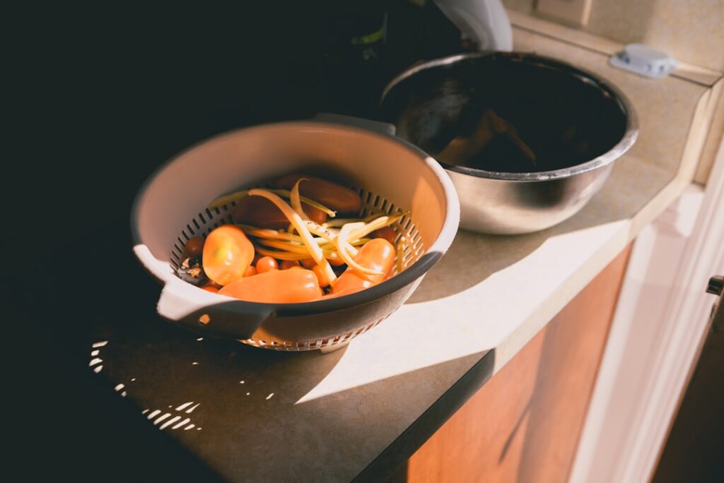 Close-up shot of a person's hands mindfully chopping fresh, colorful vegetables on a wooden cutting board in a kitchen wit...