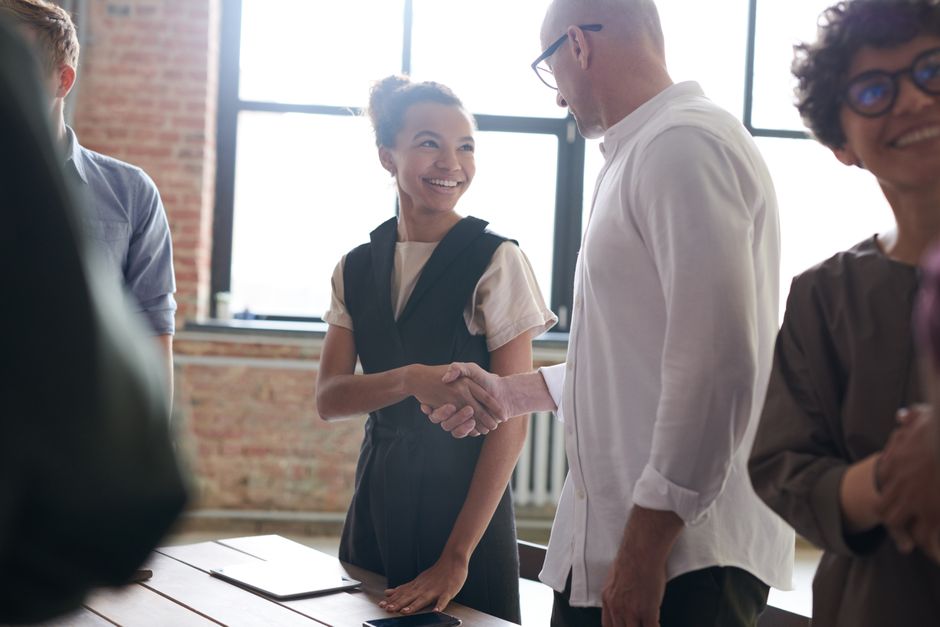 Close-up of a firm handshake between two people inside a beautifully designed modern home, signifying a successful negotiation and agreement.
